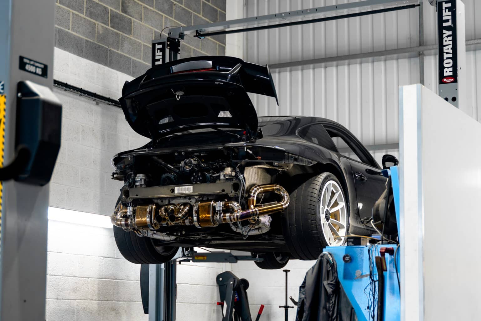 Porsche 911 on the ramp at JF Automotive with its exhaust system off